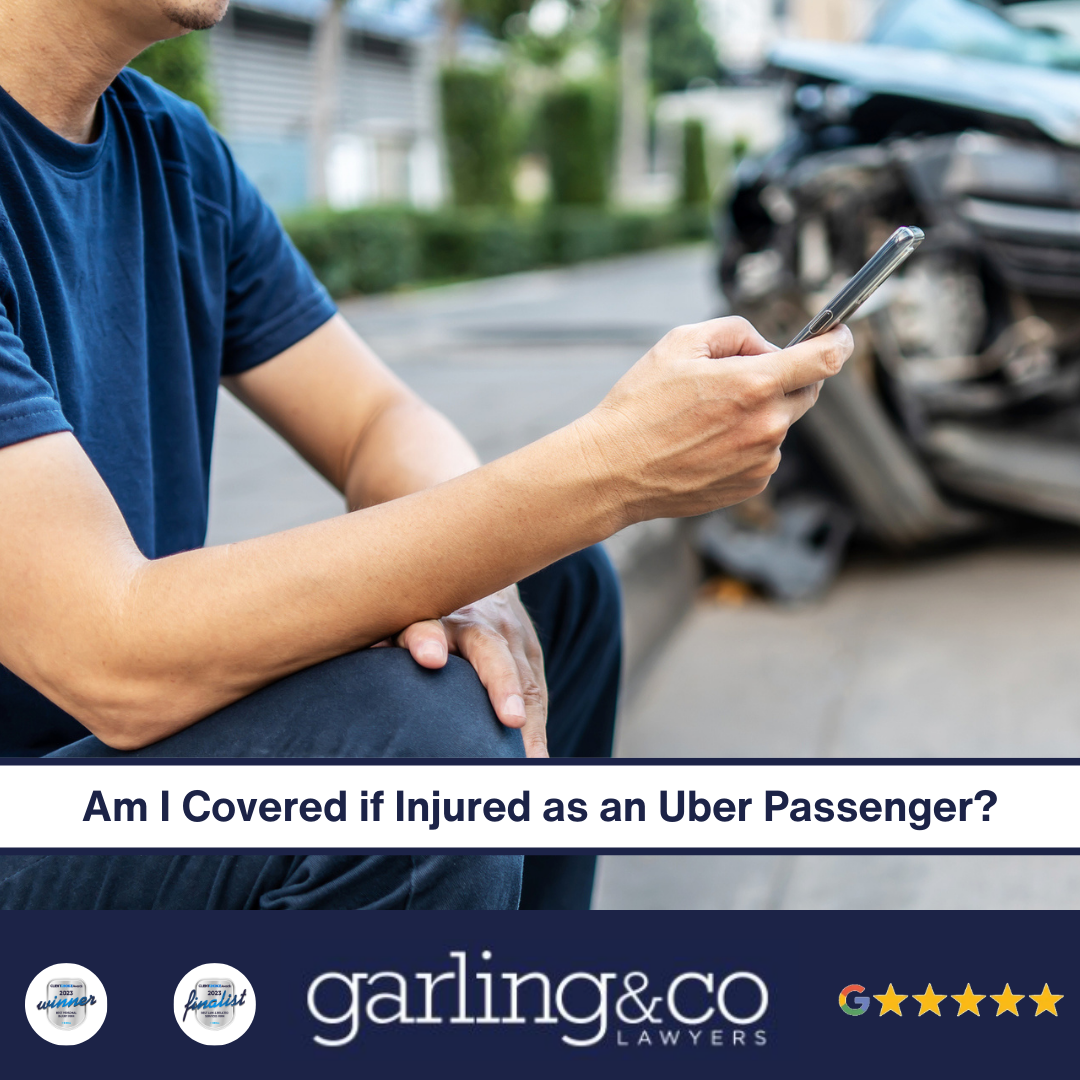 A man sitting on the sidewalk on his phone in front of a wrecked car with the caption “Am I Covered if Injured as an Uber Passenger”