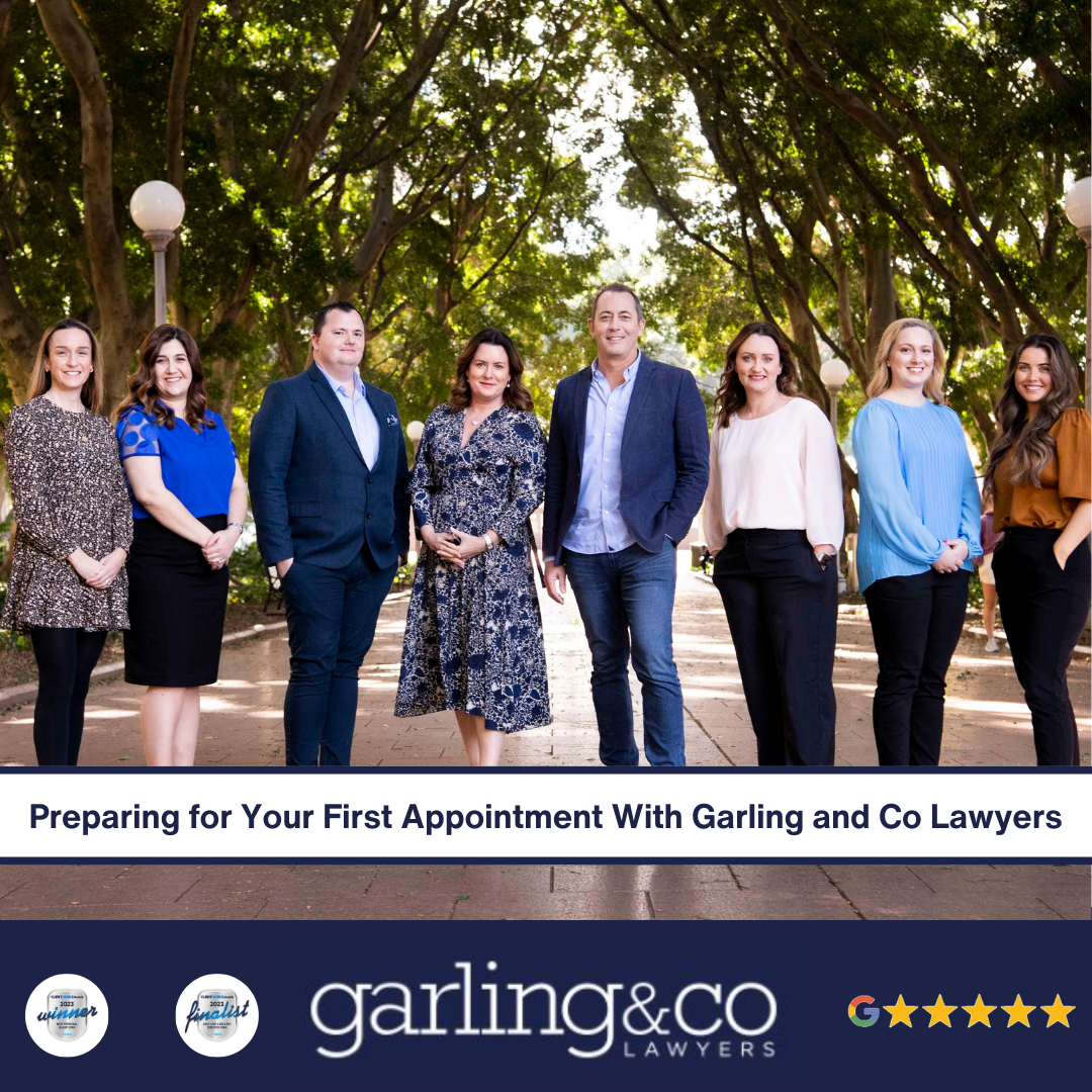 A team image of a law firm and 8 staff members, standing in a park with a backdrop of trees.
