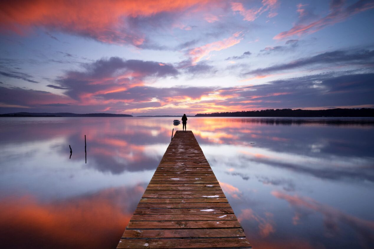 person on dock enjoying sunset. motor vehicle main image