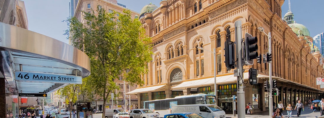 A city street with a large building in the background.